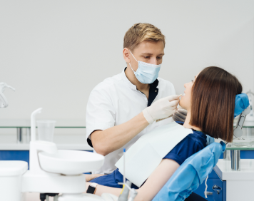close-up-portrait-beautiful-young-lady-sitting-dental-chair-while-stomatologist-hands-sterile-gloves-holding-tooth-samples-1-1.png